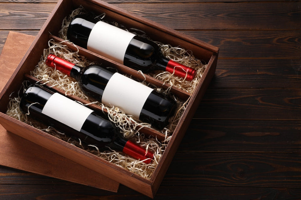 Box with wine bottles on wooden table